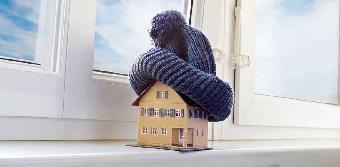 house in winter - heating system concept and cold snowy weather with model of a house