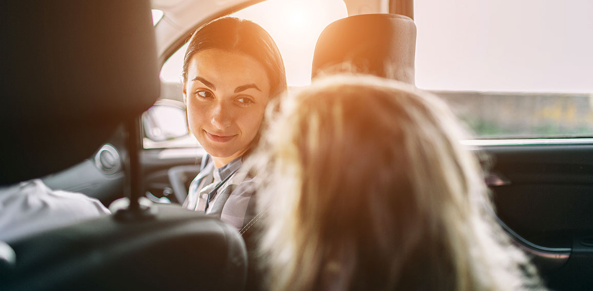 Happy family on a road trip in their car. Dad, mom and daughter are traveling by the sea or the ocean or the river. Summer ride by automobile