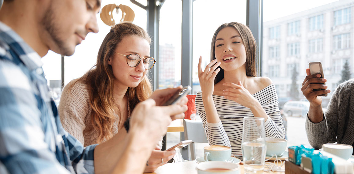 Friends using smartphones in the cafe