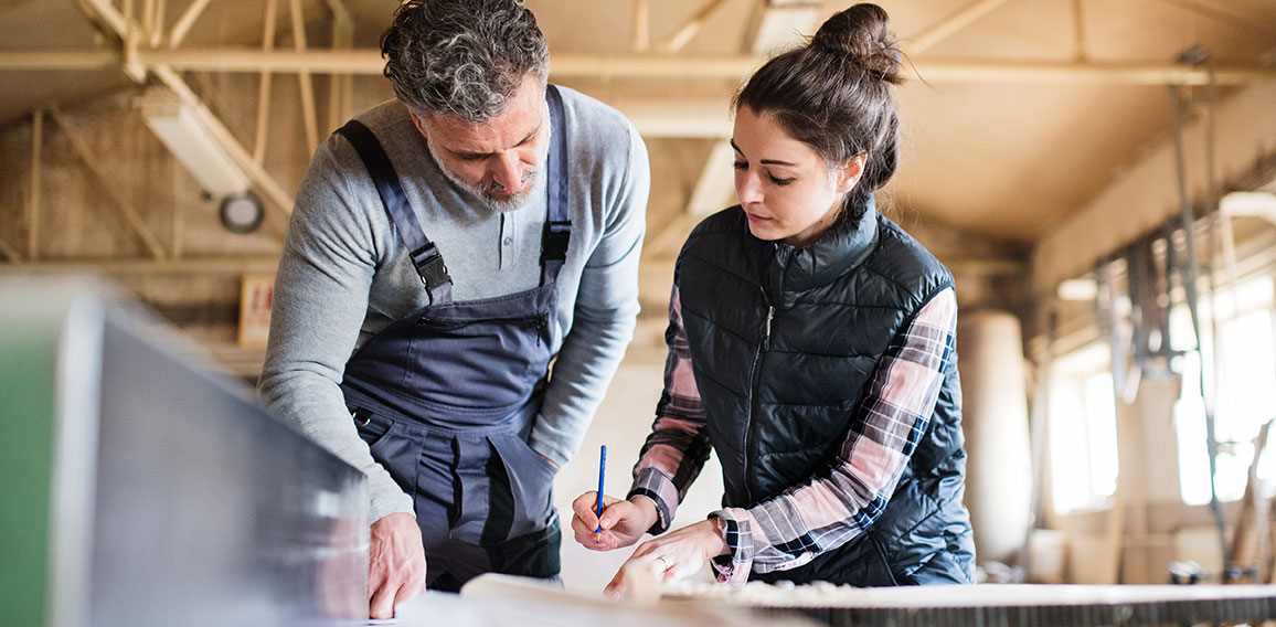 Man and woman workers working in the carpentry workshop.