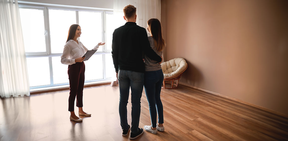 Real estate agent showing young couple a new house