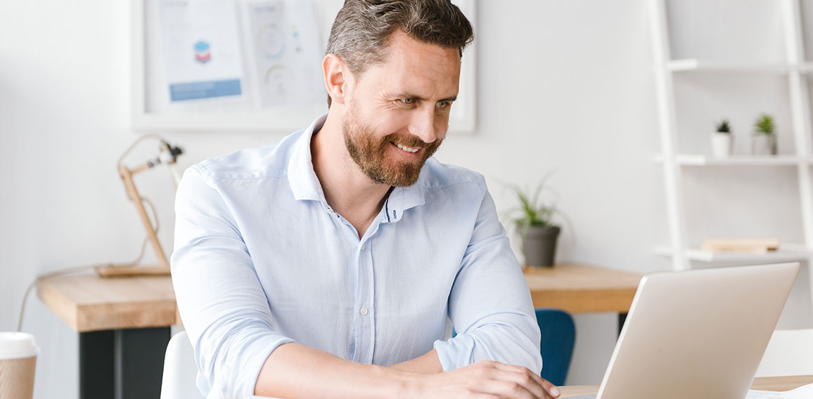 Smiling businessman working on laptop computer