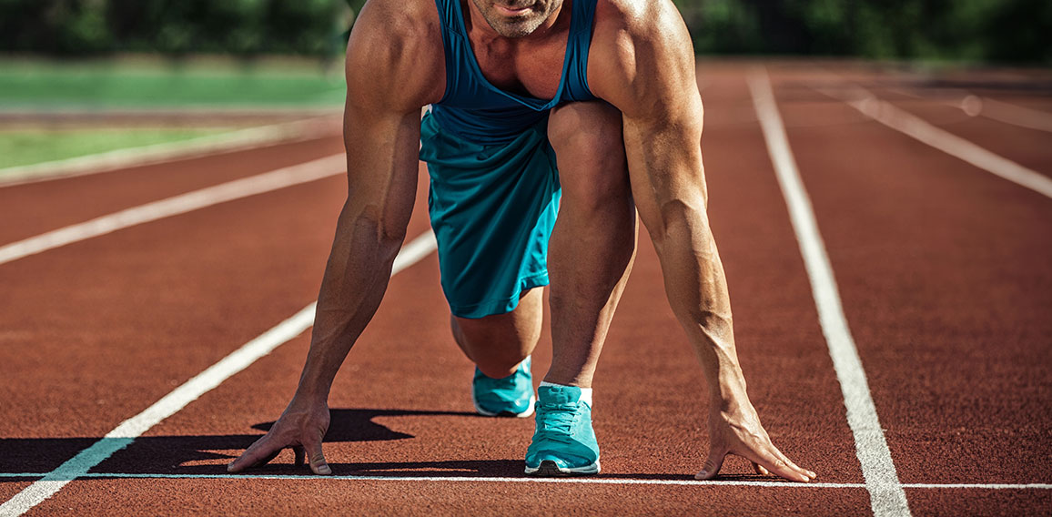 young muscular athlete is at the start of the treadmill