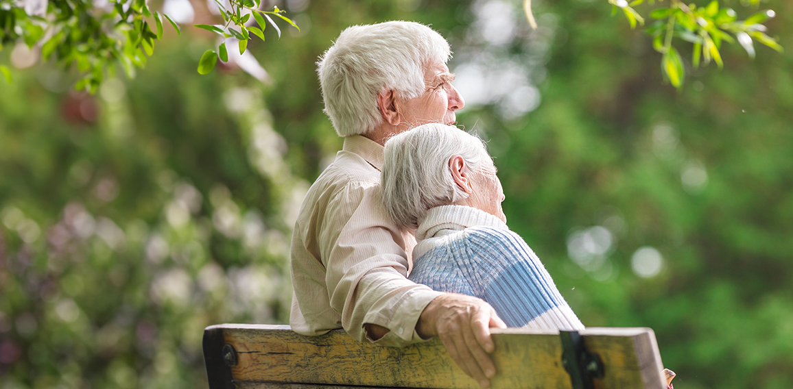 Elderly couple resting on a bench in the park