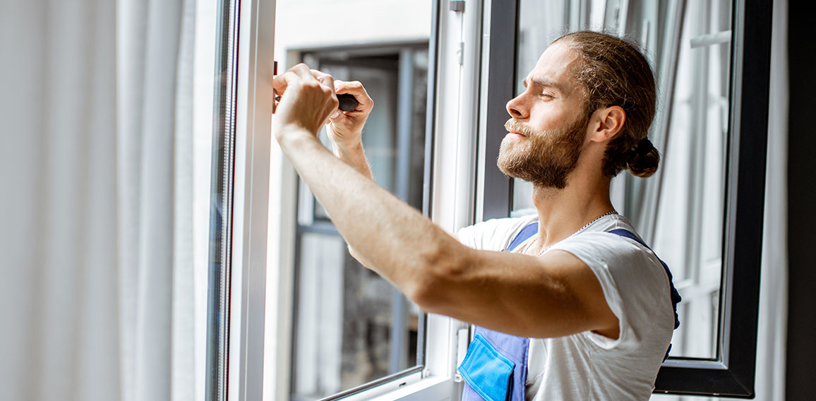 Workman adjusting window frames at home