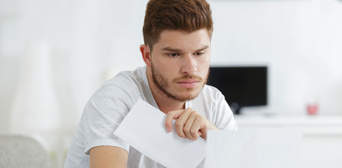 shocked man holding some documents on sofa livingroom